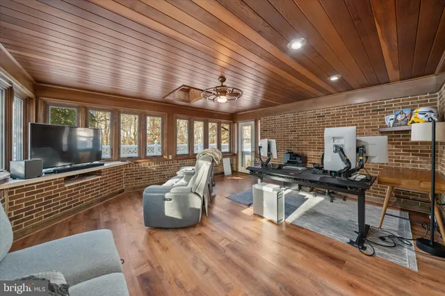 a living room with furniture a flat screen tv and a wooden floor