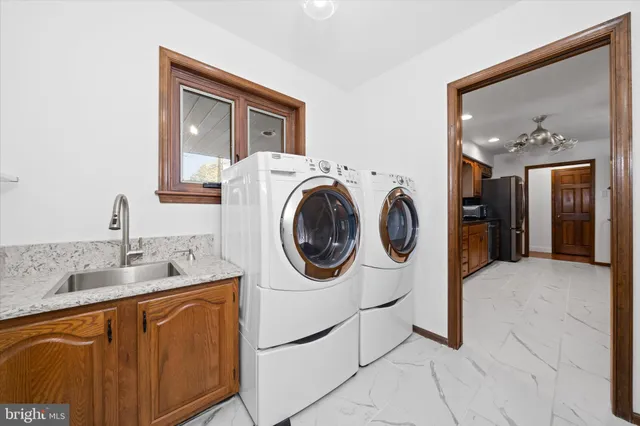 a utility room with sink dryer and washer