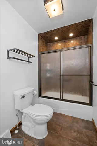 a bathroom with a toilet and a shower