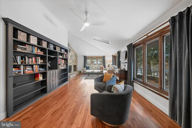 a living room with furniture a rug and a book shelf