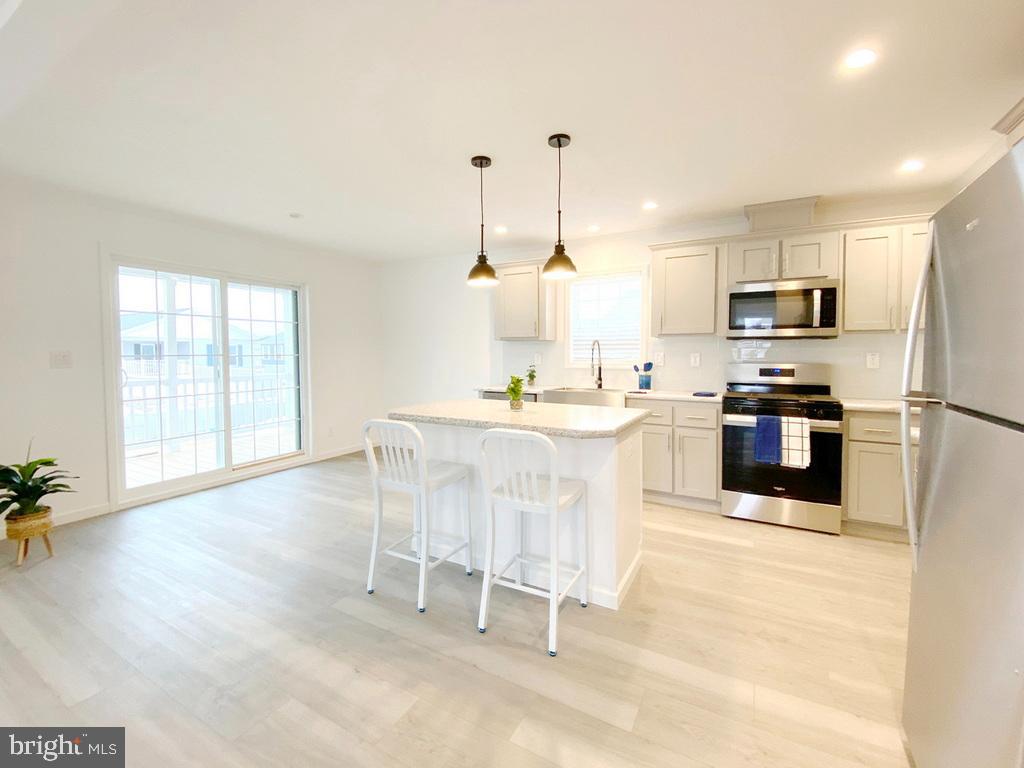11 Folkstone Lane Lewes, DE 19958 - Photo 10 of 47 a kitchen with stainless steel appliances a stove a sink a microwave a center island and a window