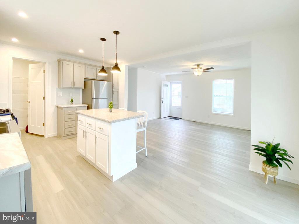 11 Folkstone Lane Lewes, DE 19958 - Photo 14 of 47 a large white kitchen with a large window a oven a stove and a chandelier