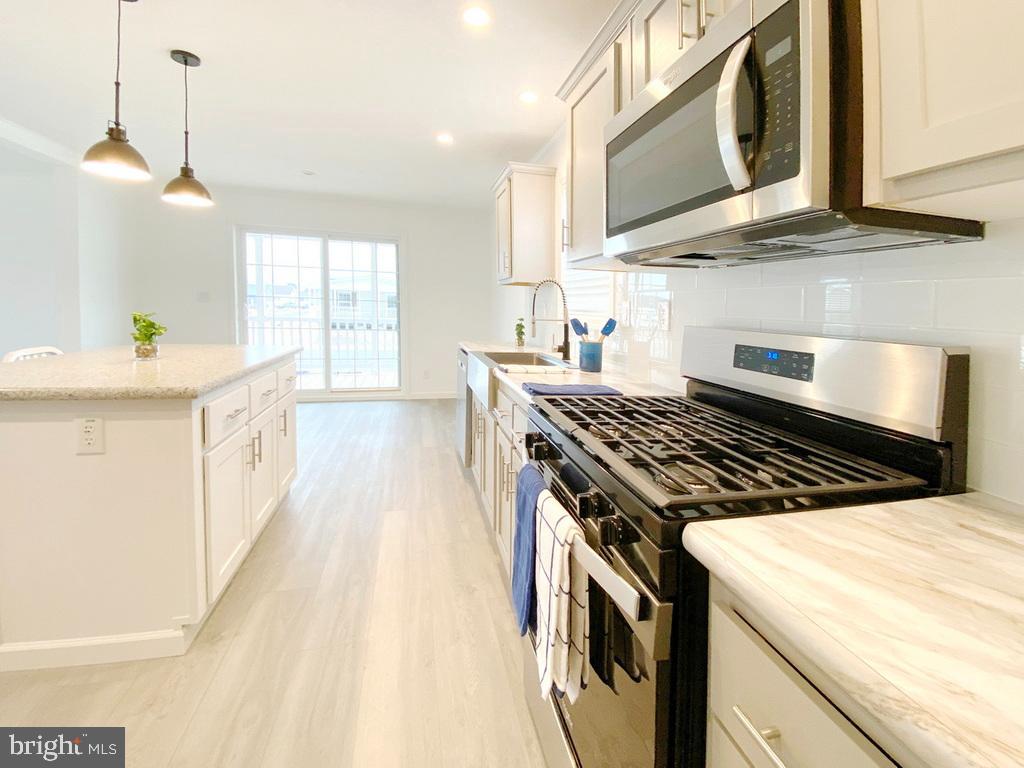 11 Folkstone Lane Lewes, DE 19958 - Photo 19 of 47 a kitchen with stainless steel appliances granite countertop a stove and a sink