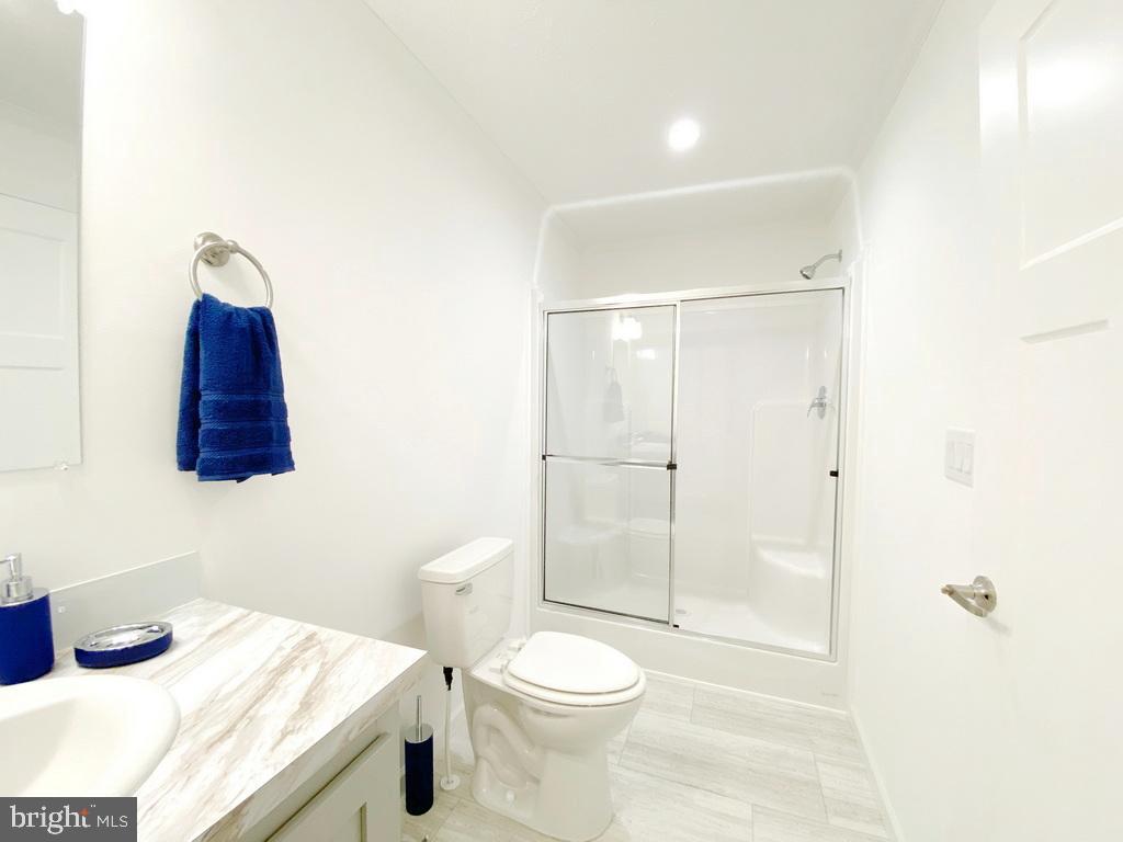 11 Folkstone Lane Lewes, DE 19958 - Photo 32 of 47 a bathroom with a granite countertop sink a toilet and shower