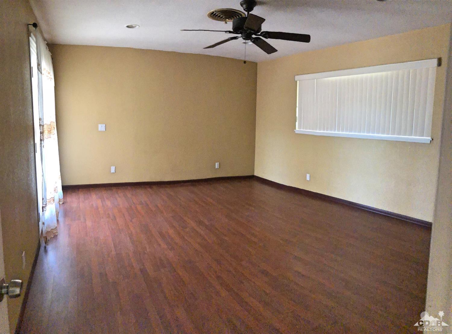 81256 Alberta Avenue Indio, CA 92201 - Photo 11 of 18 a view of an empty room with wooden floor and a window