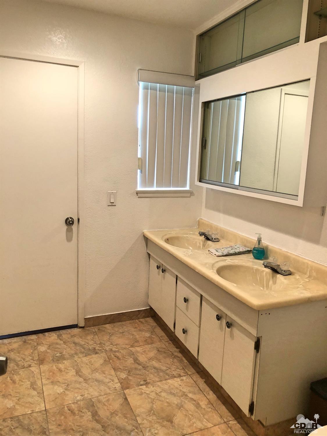 81256 Alberta Avenue Indio, CA 92201 - Photo 13 of 18 a bathroom with a granite countertop sink and a mirror