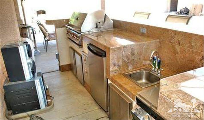 81256 Alberta Avenue Indio, CA 92201 - Photo 16 of 18 a kitchen with a sink and a stove with wooden floor
