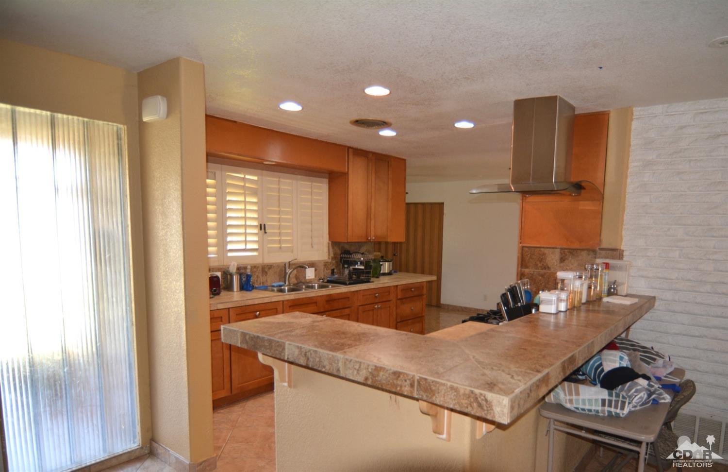 81256 Alberta Avenue Indio, CA 92201 - Photo 4 of 18 a kitchen with center island and stainless steel appliances