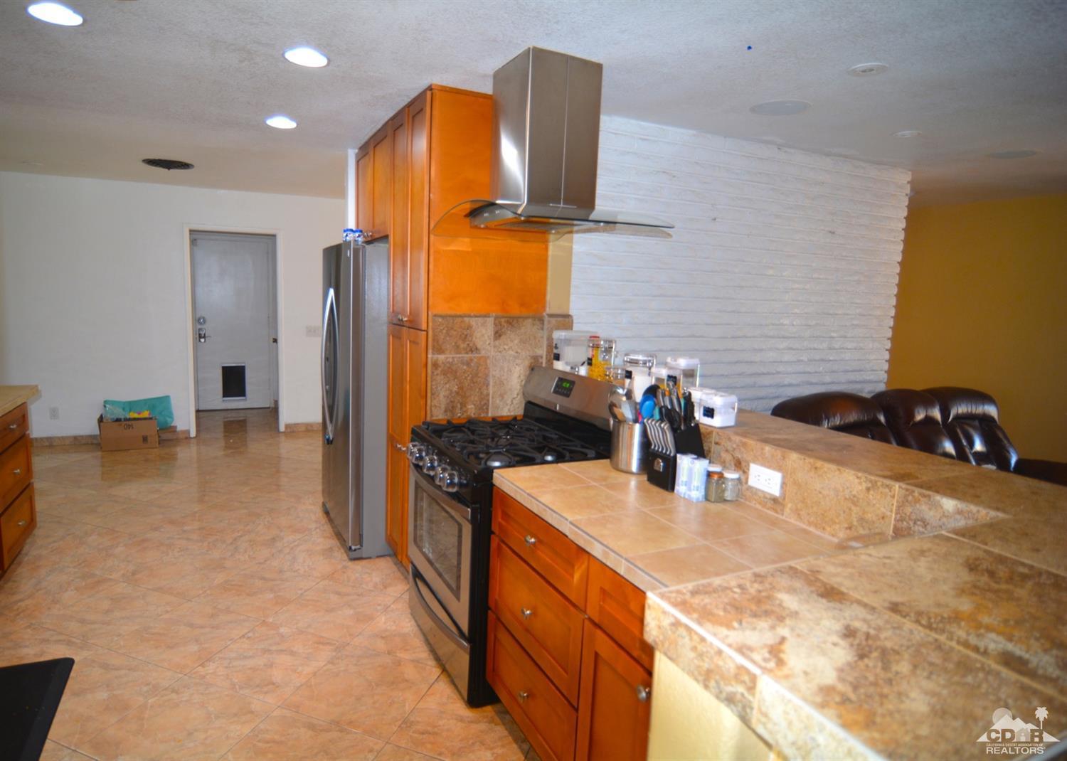 81256 Alberta Avenue Indio, CA 92201 - Photo 5 of 18 a kitchen with stainless steel appliances granite countertop a sink and a refrigerator