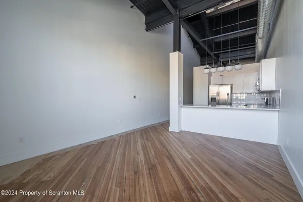 a view of an empty room with closet and a window