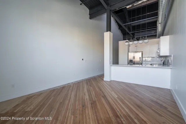 a view of an empty room with closet and a window