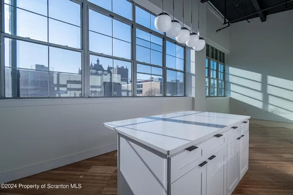 a kitchen with granite countertop a sink a counter top space and cabinets
