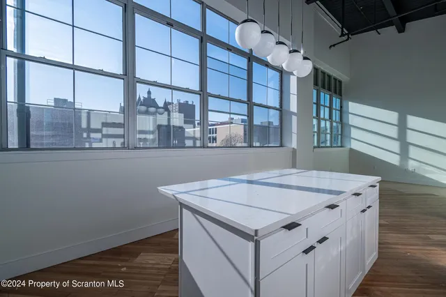 a kitchen with granite countertop a sink a counter top space and cabinets