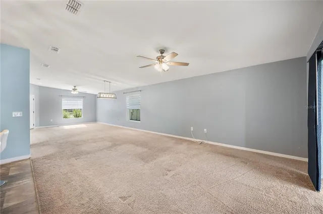 a view of a livingroom with a ceiling fan and window