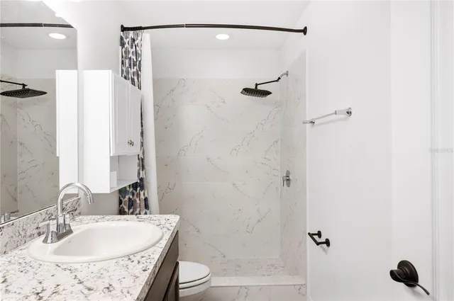 a bathroom with a sink toilet and shower