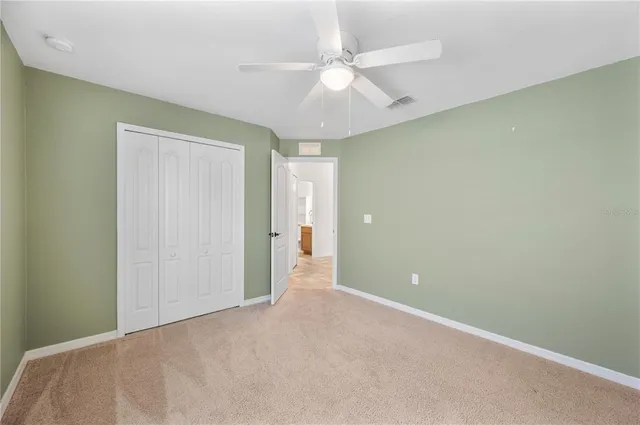 an empty room with a ceiling fan and a window