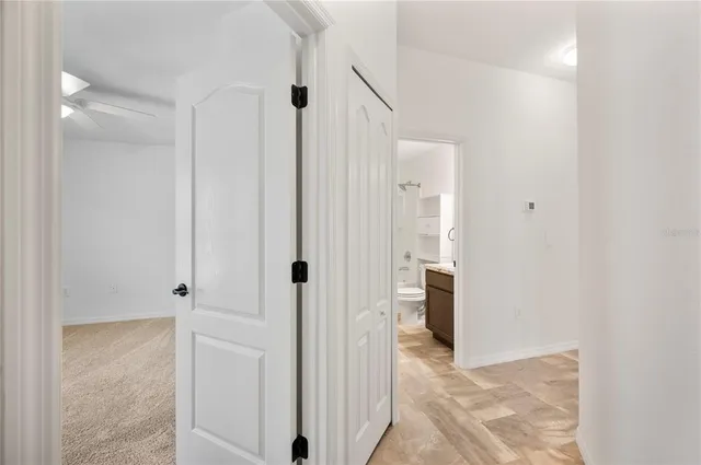 a view of a hallway with white walls and entryway