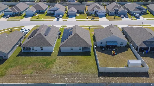an aerial view of residential houses with yard and swimming pool