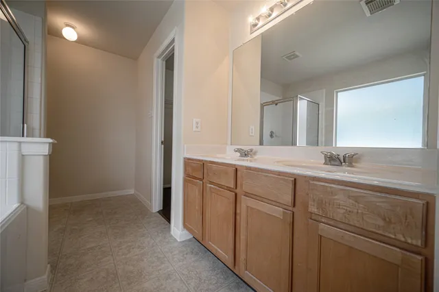 a bathroom with a double vanity sink and mirror