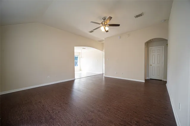 a view of an empty room with wooden floor