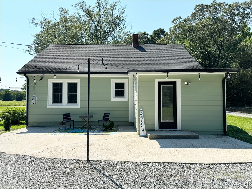 204 Pine Hall Road Mathews, VA 23109 - Photo 27 of 29 Rear view of property with a patio, string lights and a circle driveway.