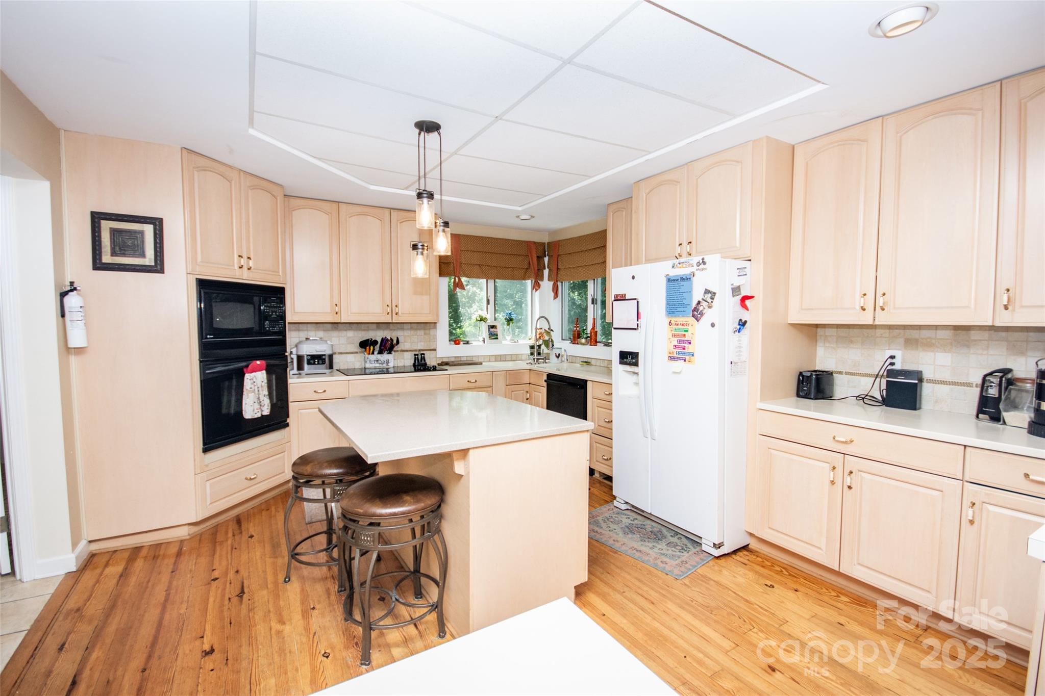 10245 Cool Springs Road Cleveland, NC 27013 - Photo 11 of 48 a kitchen with stainless steel appliances kitchen island granite countertop a refrigerator a sink dishwasher and white cabinets with wooden floor