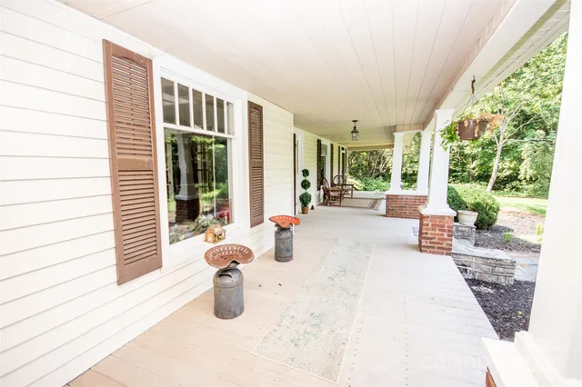 a view of a house with a barbeque and wooden stairs