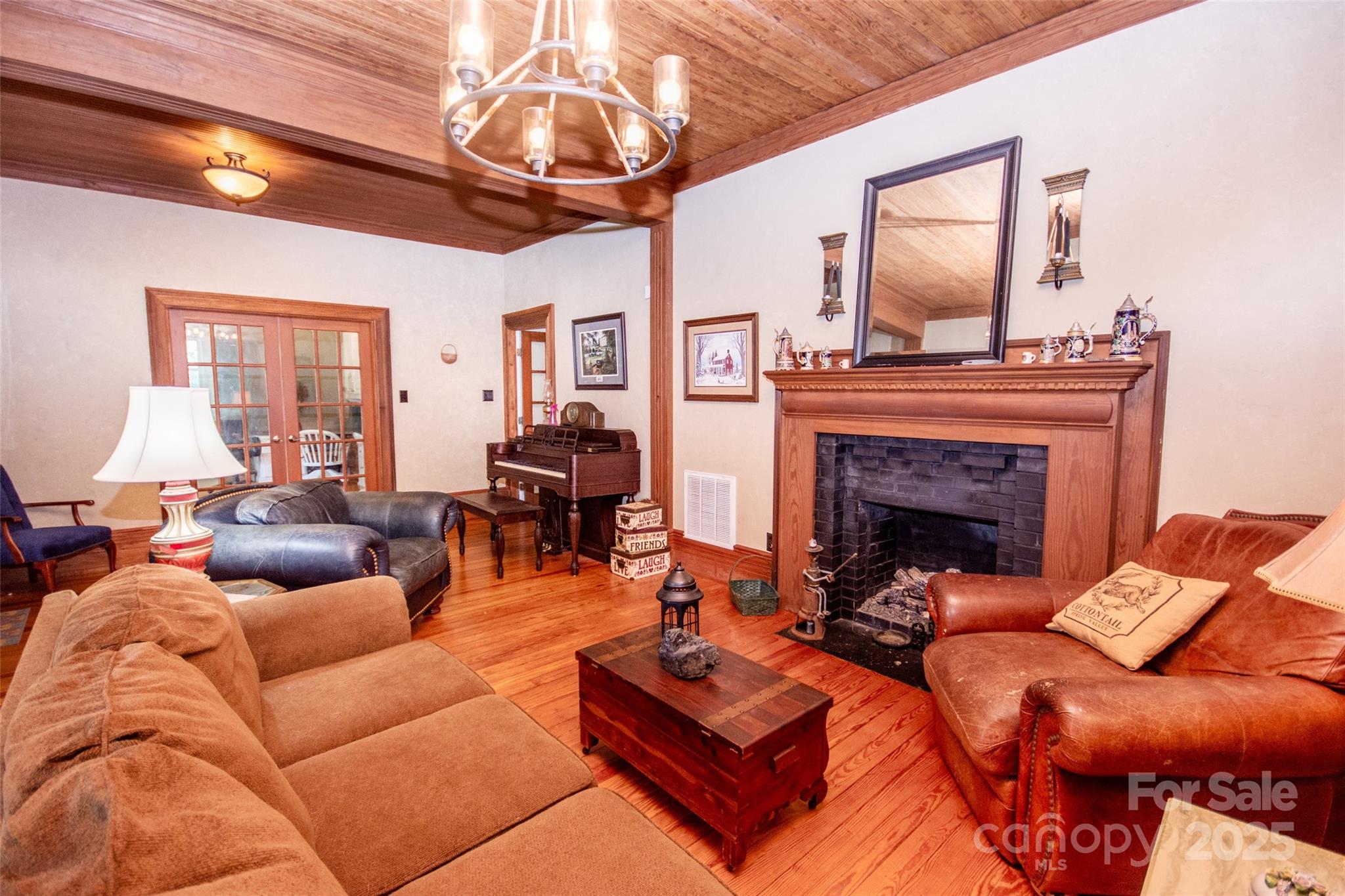 10245 Cool Springs Road Cleveland, NC 27013 - Photo 6 of 48 a living room with furniture a fireplace and a chandelier