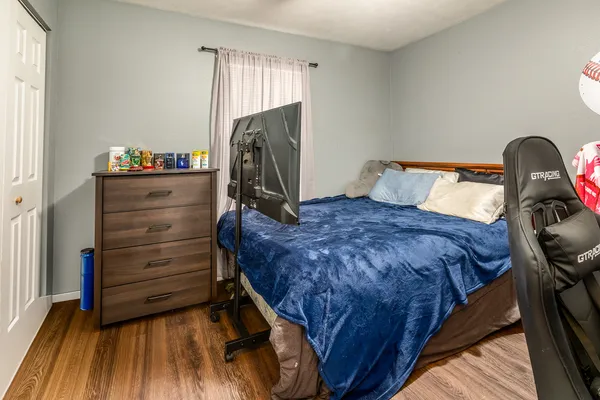 a bed sitting in a bedroom next to a window and dresser