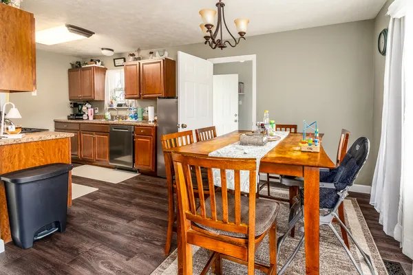 a dining room with furniture a chandelier and wooden floor