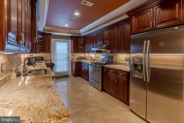 a large kitchen with stainless steel appliances granite countertop a stove sink and cabinets