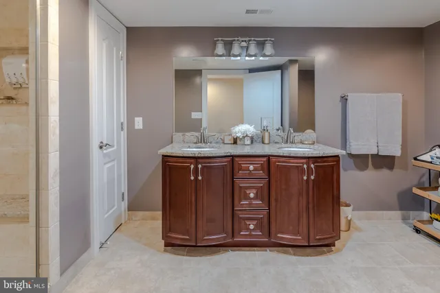 a bathroom with a granite countertop sink and a mirror