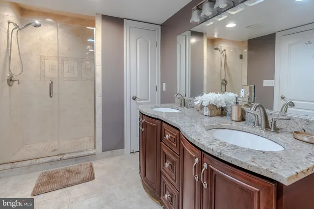 a bath room with a granite countertop sink and a mirror