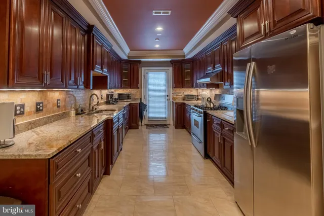 a kitchen with stainless steel appliances granite countertop a stove a sink dishwasher a refrigerator and a oven