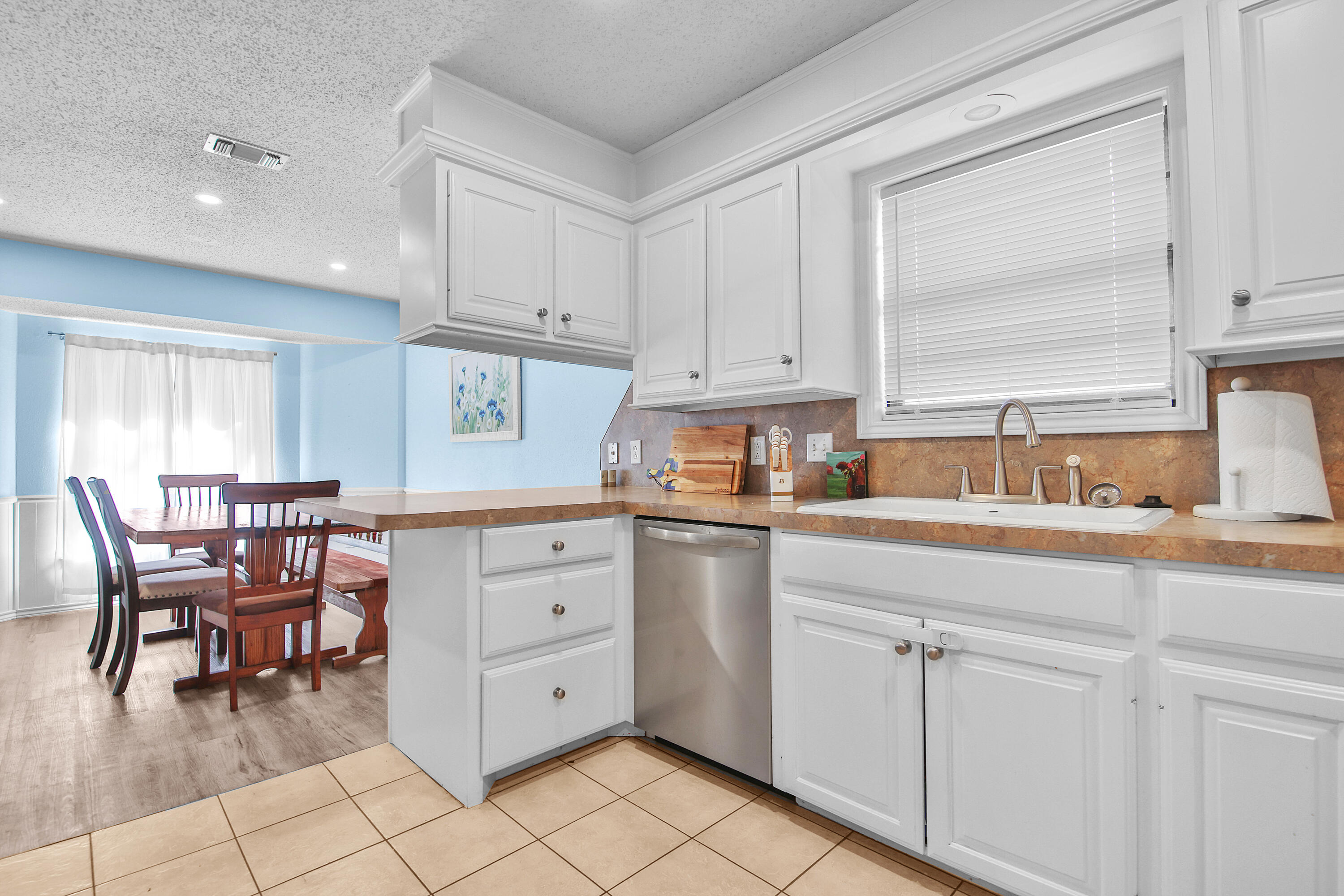 4805 73rd Street Lubbock, TX 79424 - Photo 10 of 26 a kitchen with a white cabinets and chairs