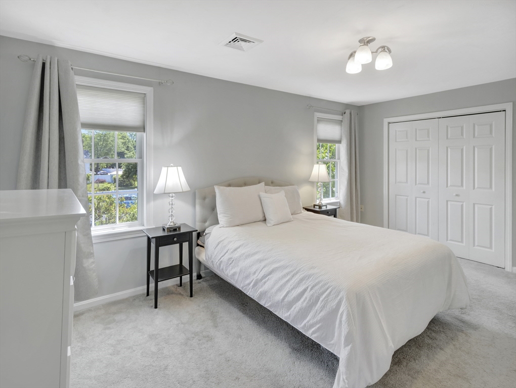 13 Shawmut Avenue, Unit 13 Mansfield, MA 02048 - Photo 15 of 34 a bedroom with a bed and a table lamp