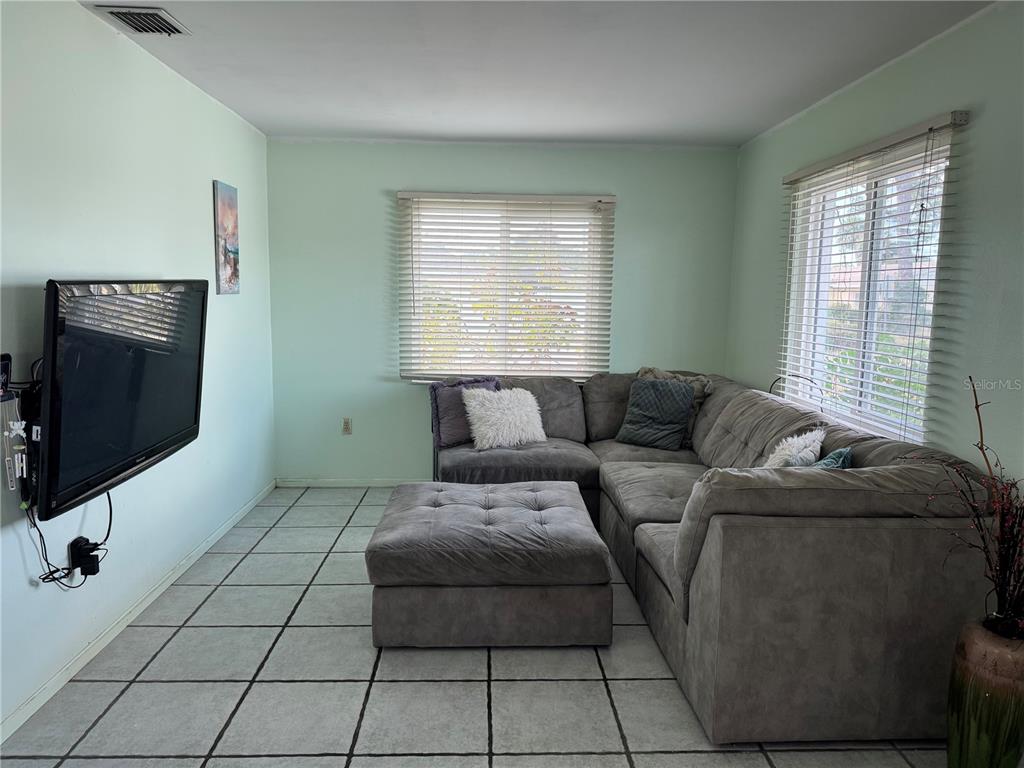 1048 Porpoise Road Venice, FL 34293 - Photo 9 of 26 a living room with a couch and a flat screen tv