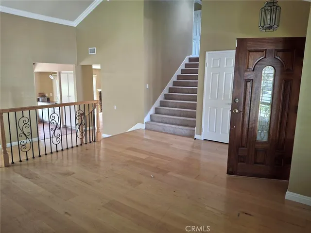 a view of entryway and hall with wooden floor