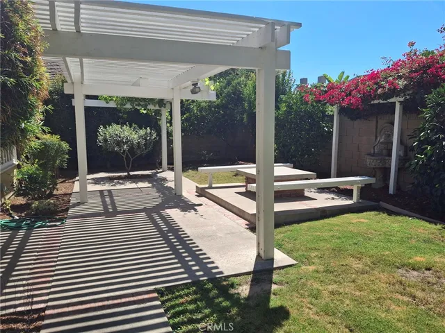 a view of a patio with a table and chairs and potted plants