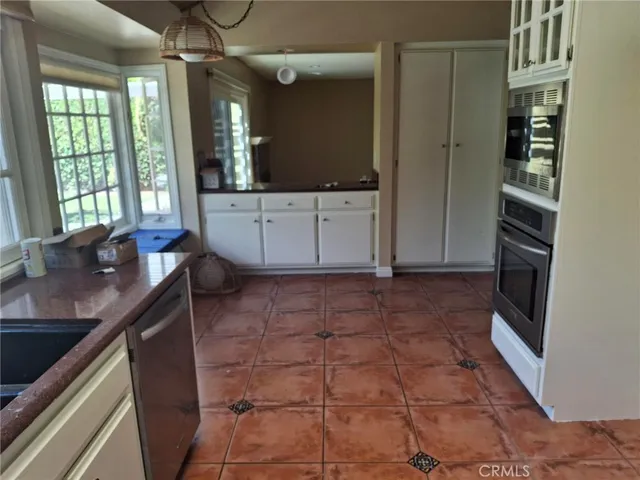 a kitchen with granite countertop a sink a stove and cabinets