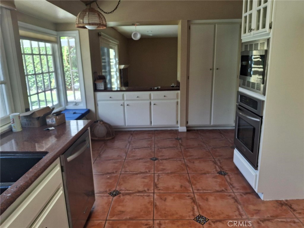 12 Hidalgo Irvine, CA 92620 - Photo 5 of 24 a kitchen with granite countertop a sink a stove and cabinets