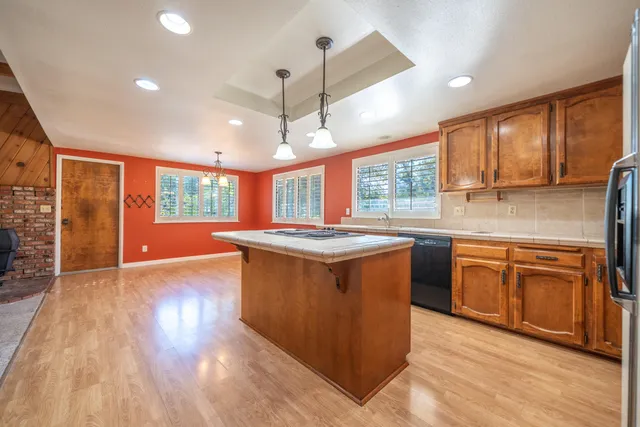 a kitchen with kitchen island granite countertop a stove and a wooden floors