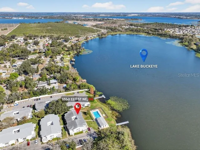 an aerial view of ocean and residential houses with outdoor space