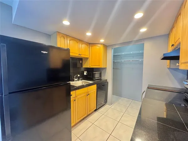 a kitchen with stainless steel appliances granite countertop a refrigerator a sink and a stove