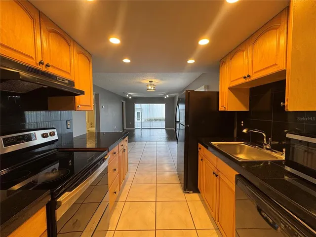 a large kitchen with stainless steel appliances granite countertop a sink and a stove