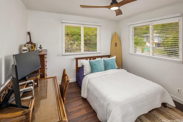 a bedroom with a bed and wooden floor