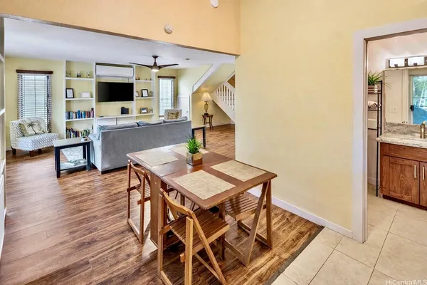 a living room with furniture a flat screen tv and kitchen view