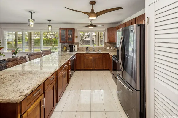 a large kitchen with kitchen island granite countertop a large counter top appliances and cabinets