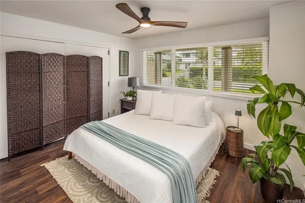 a bedroom with a bed potted plant with the large window