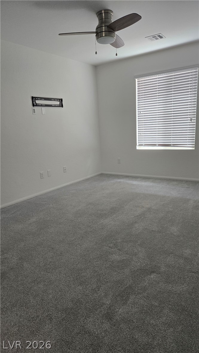 891 Earth Luster Road Las Vegas, NV 89178 - Photo 9 of 20 Plush wall-to-wall carpeting and a wide window with horizontal blinds anchor this quiet bedroom.